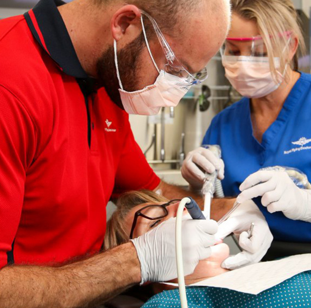 Dentist and assistant working on female patients teeth