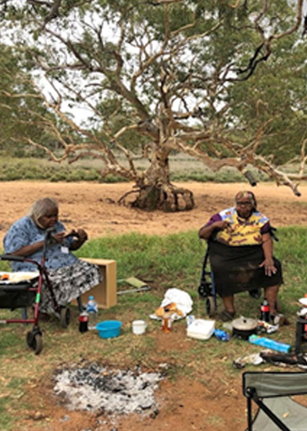 Senior aged women eating outside near a dry river bed