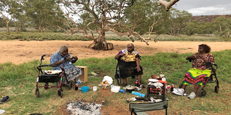 Senior aged women eating outside near a dry river bed