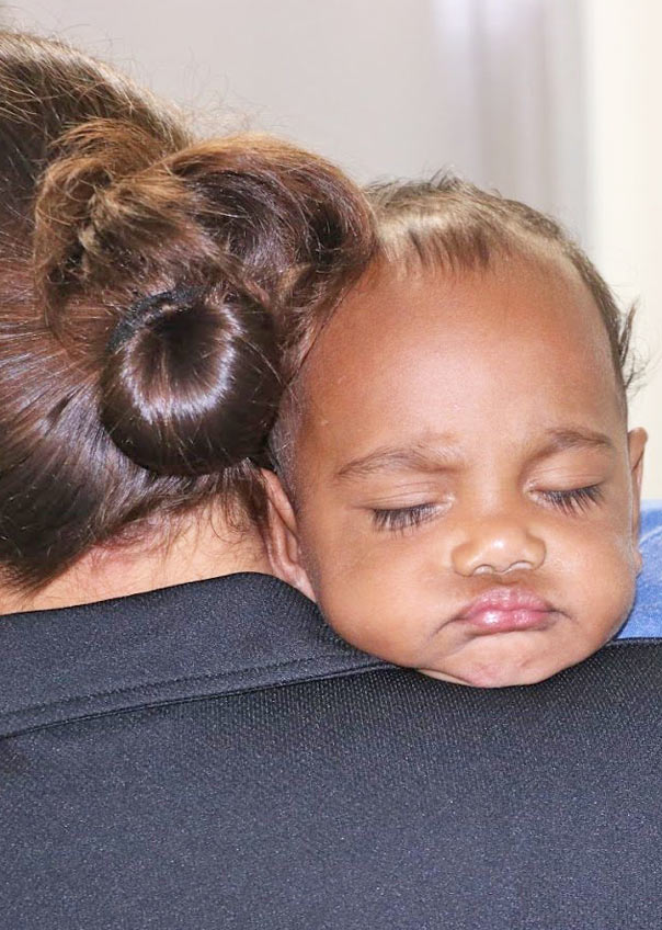 Young baby asleep on a shoulder