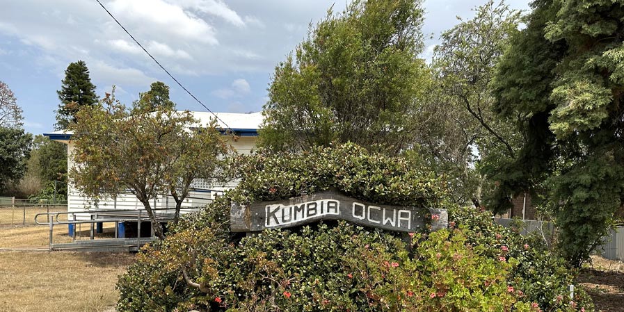 Kumbia QCWA building with sign and bushes