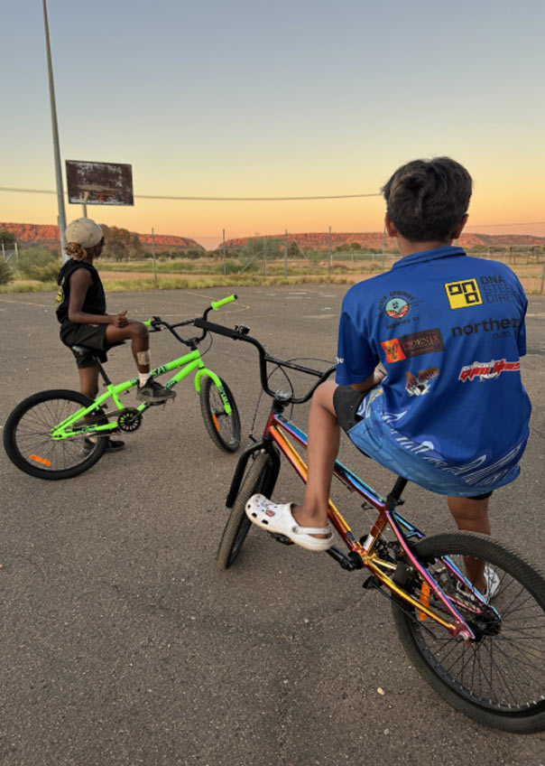 Two boys on BMX bikes at sunset