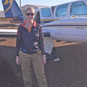 Cara Sheppard in front of a small aircraft