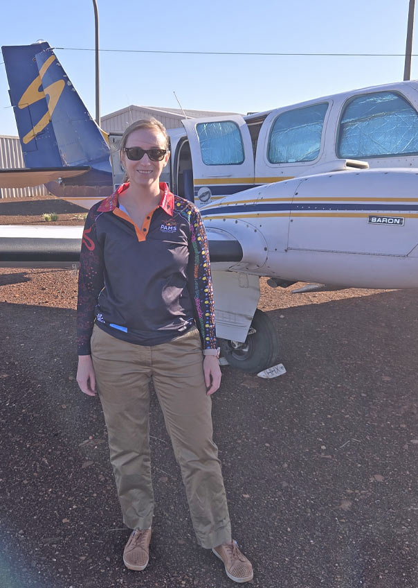 Cara Sheppard in front of a small aircraft