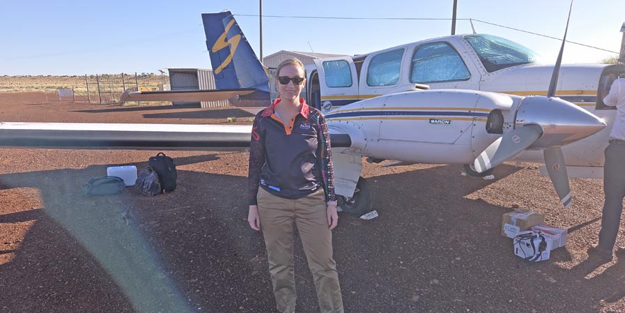 Cara Sheppard in front of a small aircraft