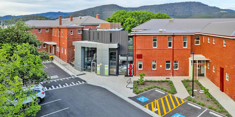 red brick medical training facility with mountains in the background