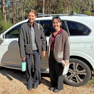Photo shows Amelia (left) and Sakura (right) in the Karri forest at their accommodation, about to hit the road!