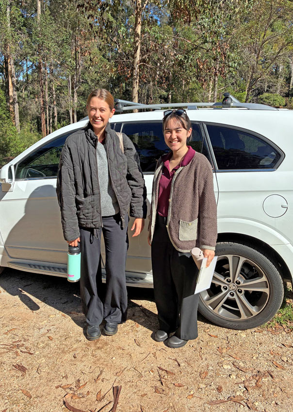 Photo shows Amelia (left) and Sakura (right) in the Karri forest at their accommodation, about to hit the road!