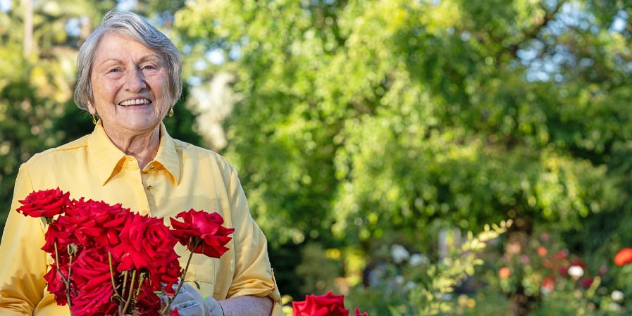 Mature woman with red roses in a park
