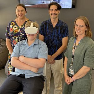 Student wearing VR headset with three other people