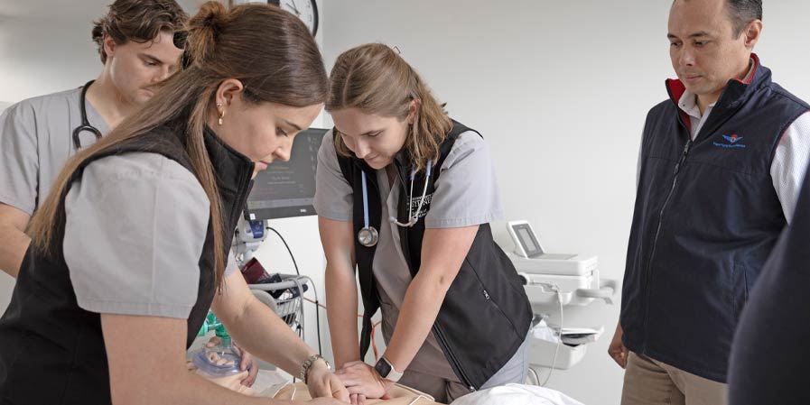 Students working on a medical training dummy