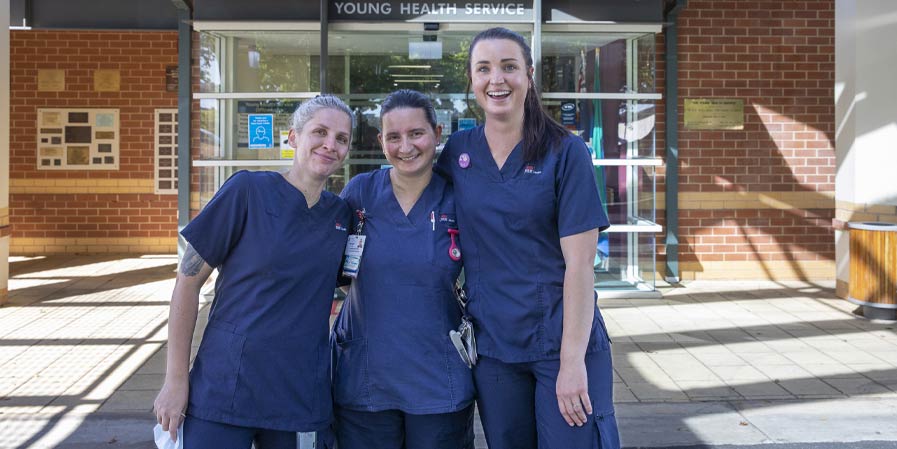 Three medical workers in blue uniforms