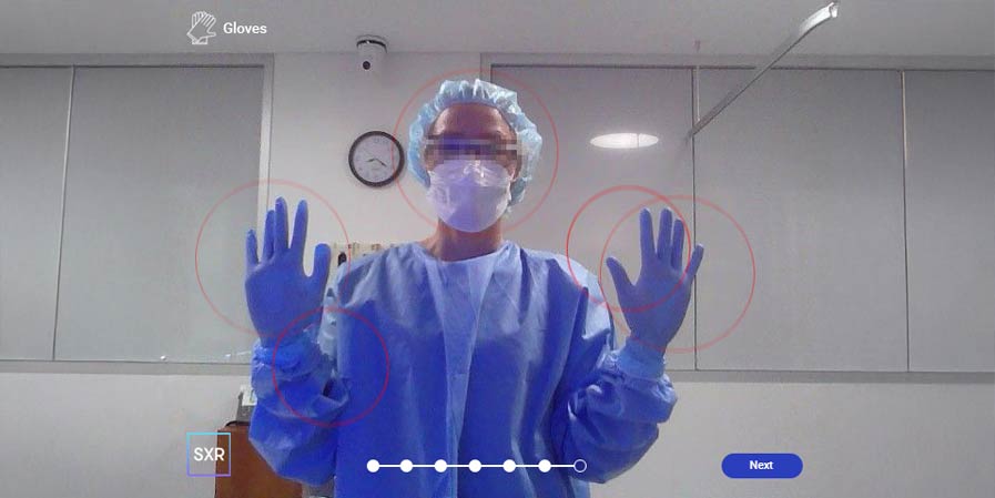 Person in PPE with hands up facing camera