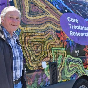 Man standing next to colourful mobile clinic van