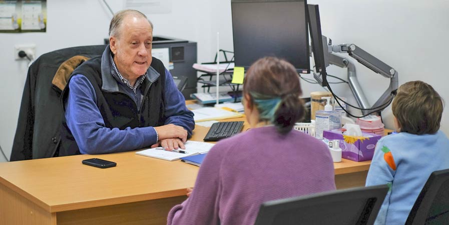 Dr Timothy McCrossin (Paediatrician) consulting with a patient and family member