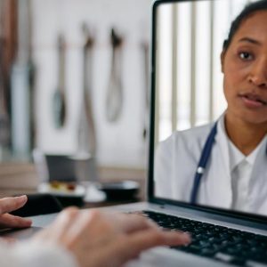 Older woman using. a laptop to talk to a doctor