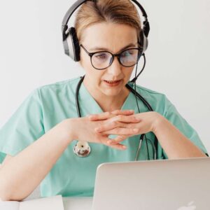 Doctor with headset on phone call with laptop in front