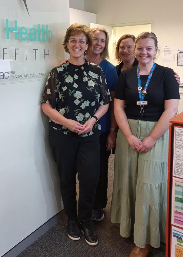 Group of four people standing front of business sign "Your Health Griffith"